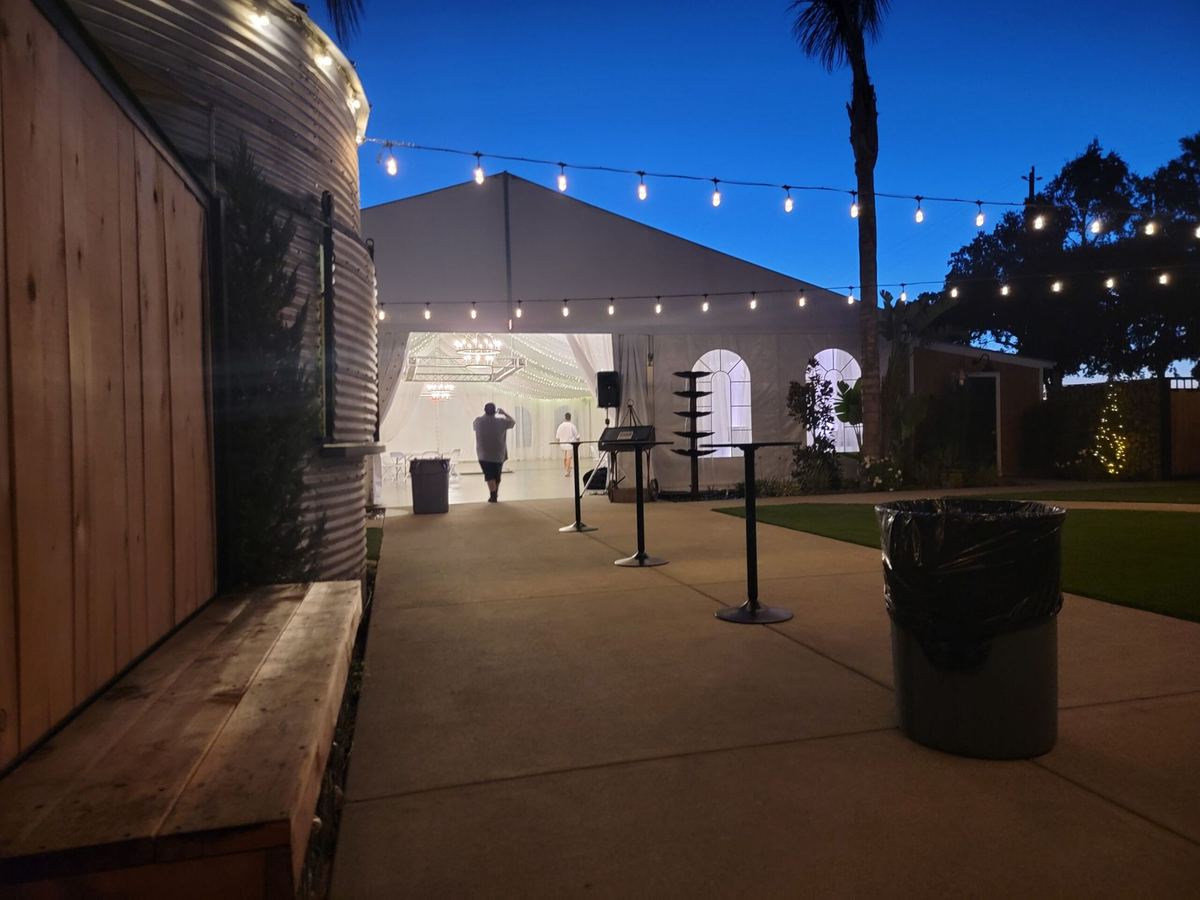 String lights over the courtyard outside The Silos Event Center at dusk